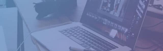 an opened laptop sitting on a desk with a blue and purple colored overlay.